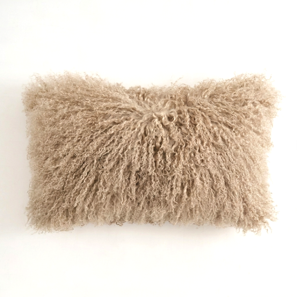 Dark beige Mongolian lamb fur pillow on a white background