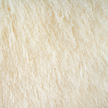 Close-up of natural Mongolian lamb fur showing long curly wool texture with soft dense and fluffy natural fibers for luxury home decor material detail
